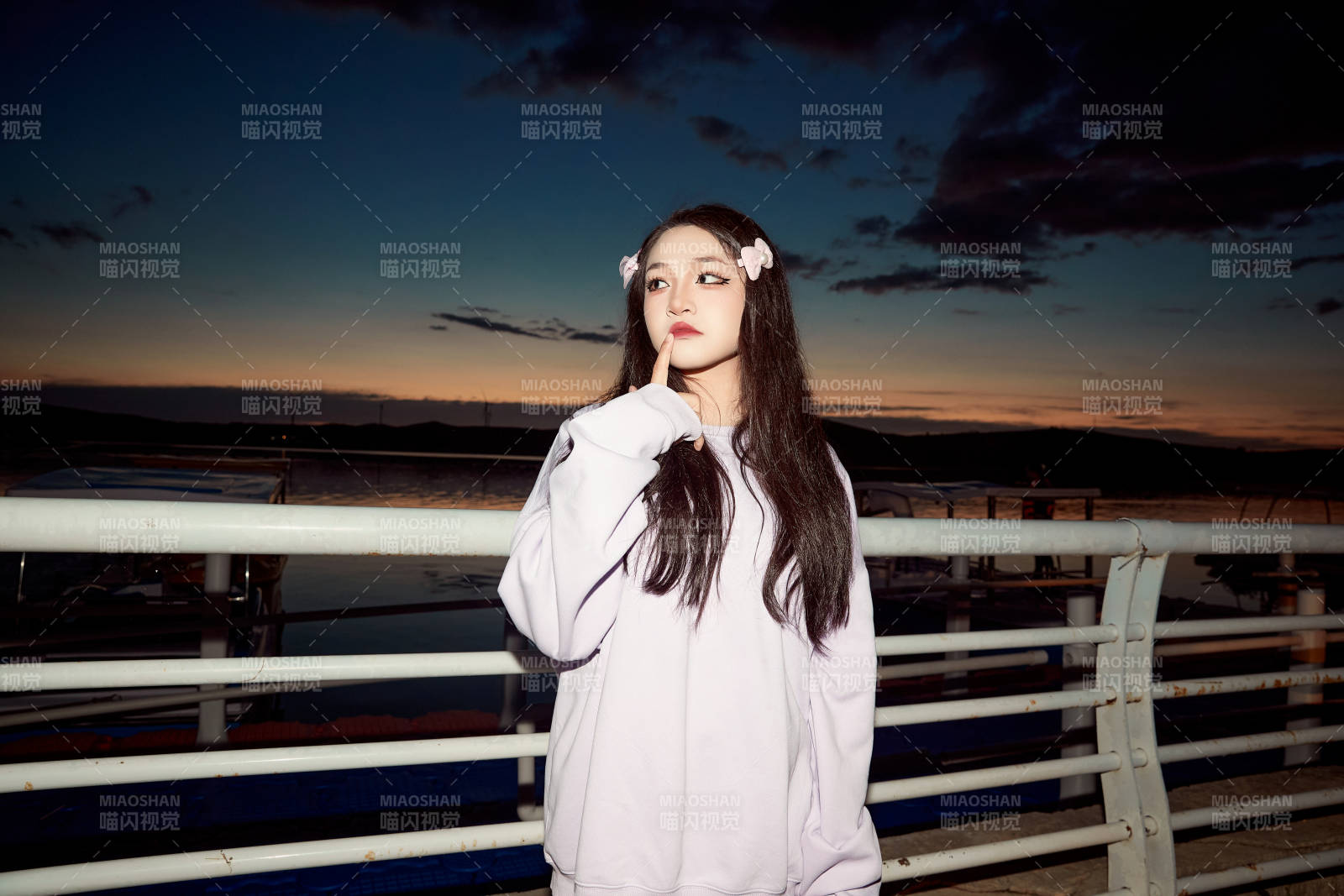 傍晚在湖邊欣賞風景拍照的亞洲美女