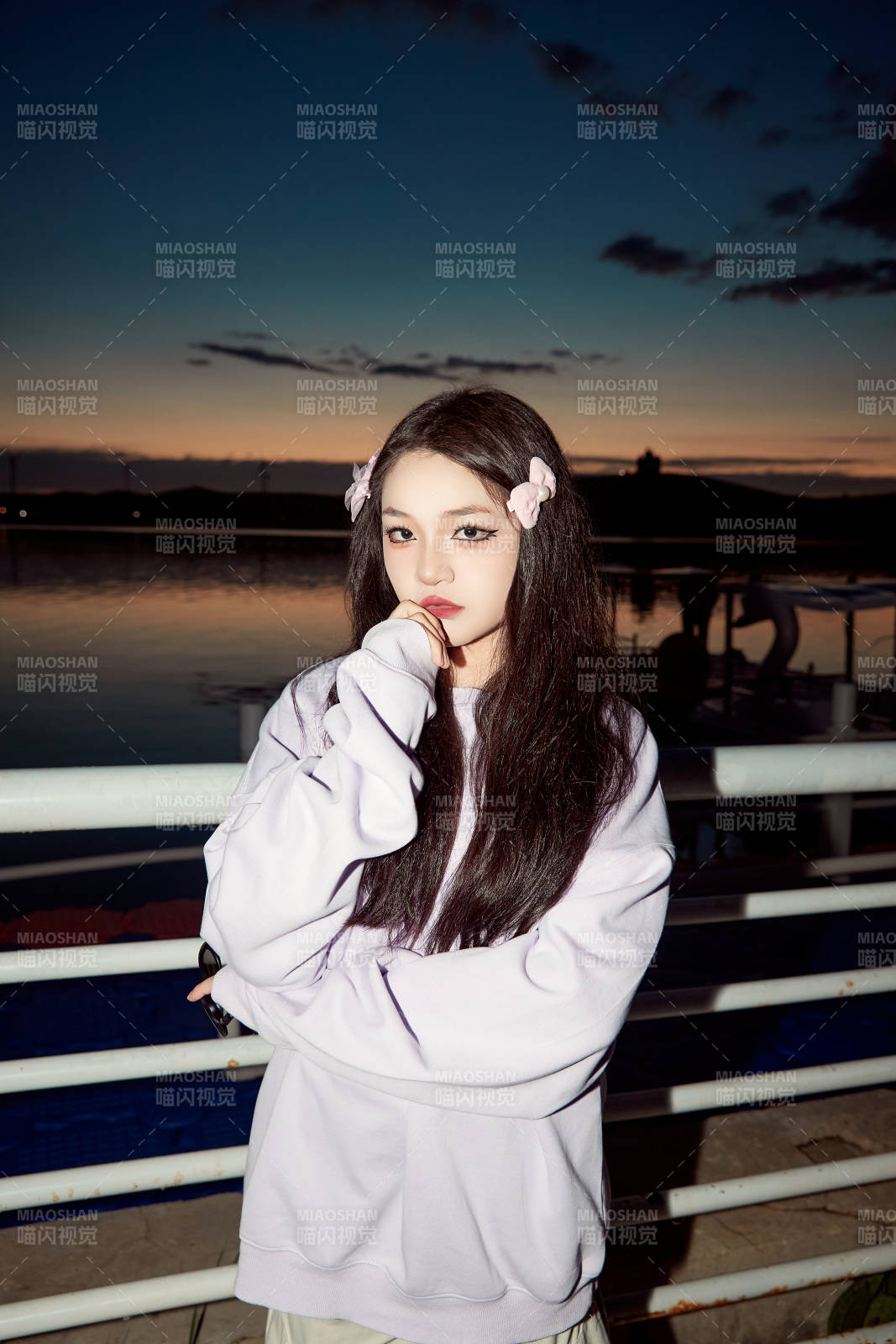 傍晚在湖边欣赏风景拍照的亚洲美女