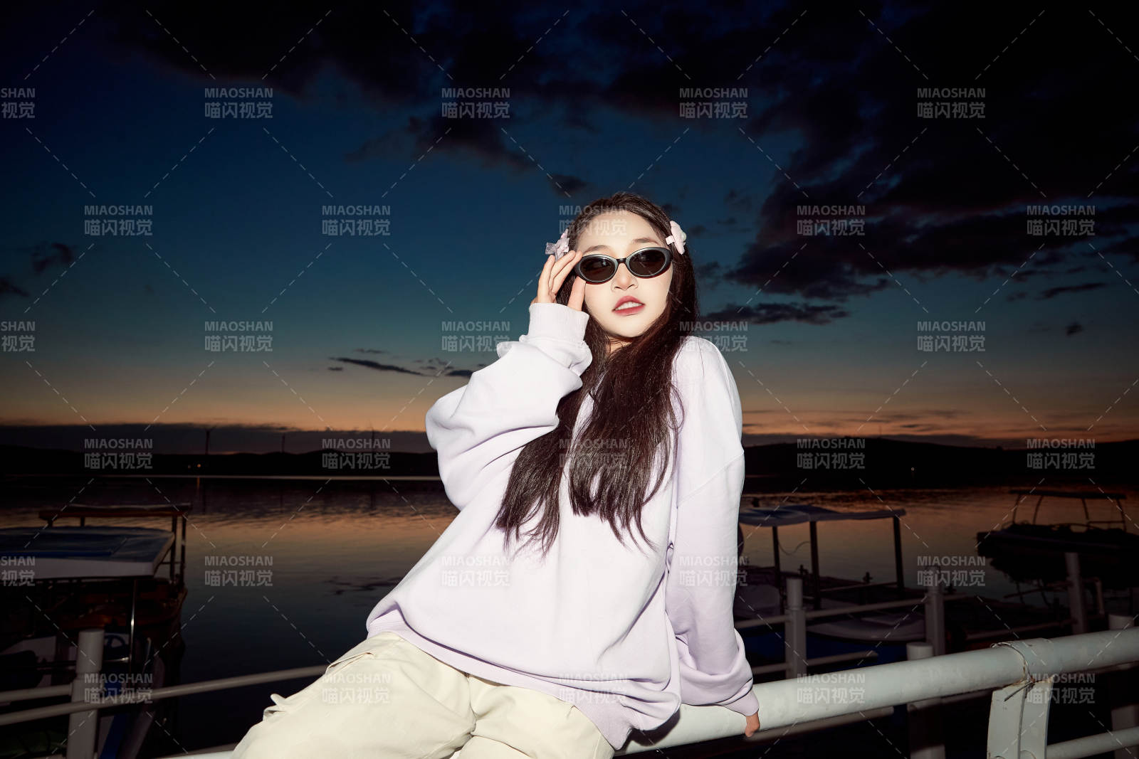 傍晚在湖邊欣賞風(fēng)景拍照的亞洲美女