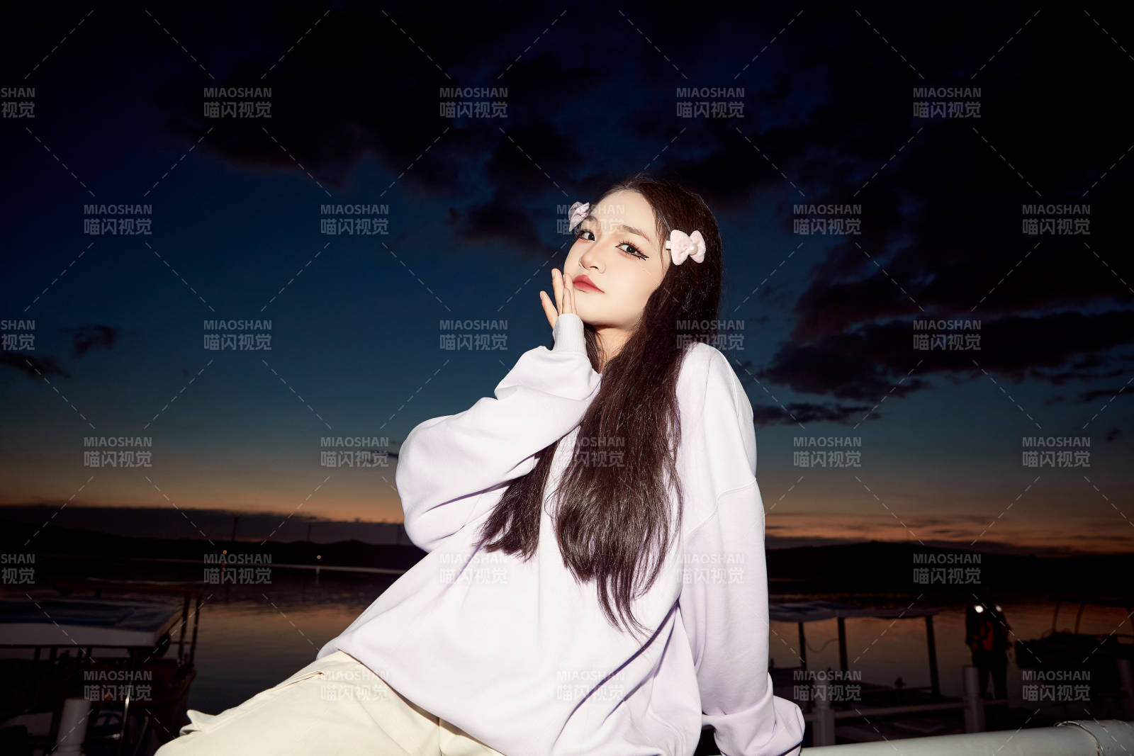 傍晚在湖边欣赏风景拍照的亚洲美女图片