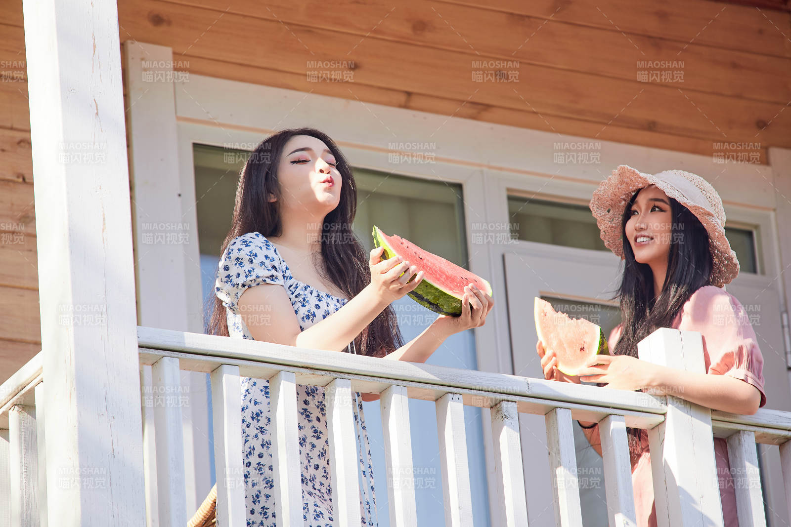 夏天在木質別墅門廊外吃西瓜的美女