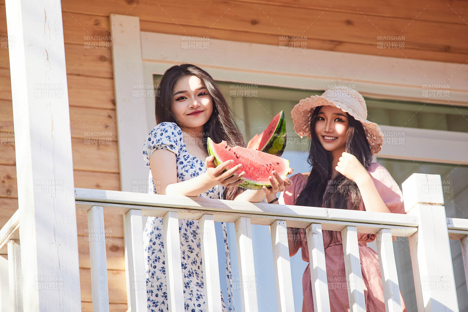 夏天在木质别墅门廊外吃西瓜的美女