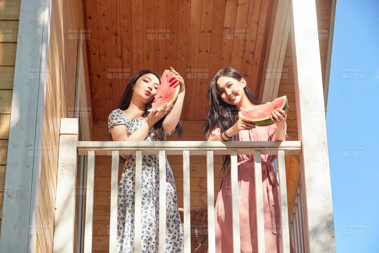 夏天在木質(zhì)別墅門廊外吃西瓜的美女