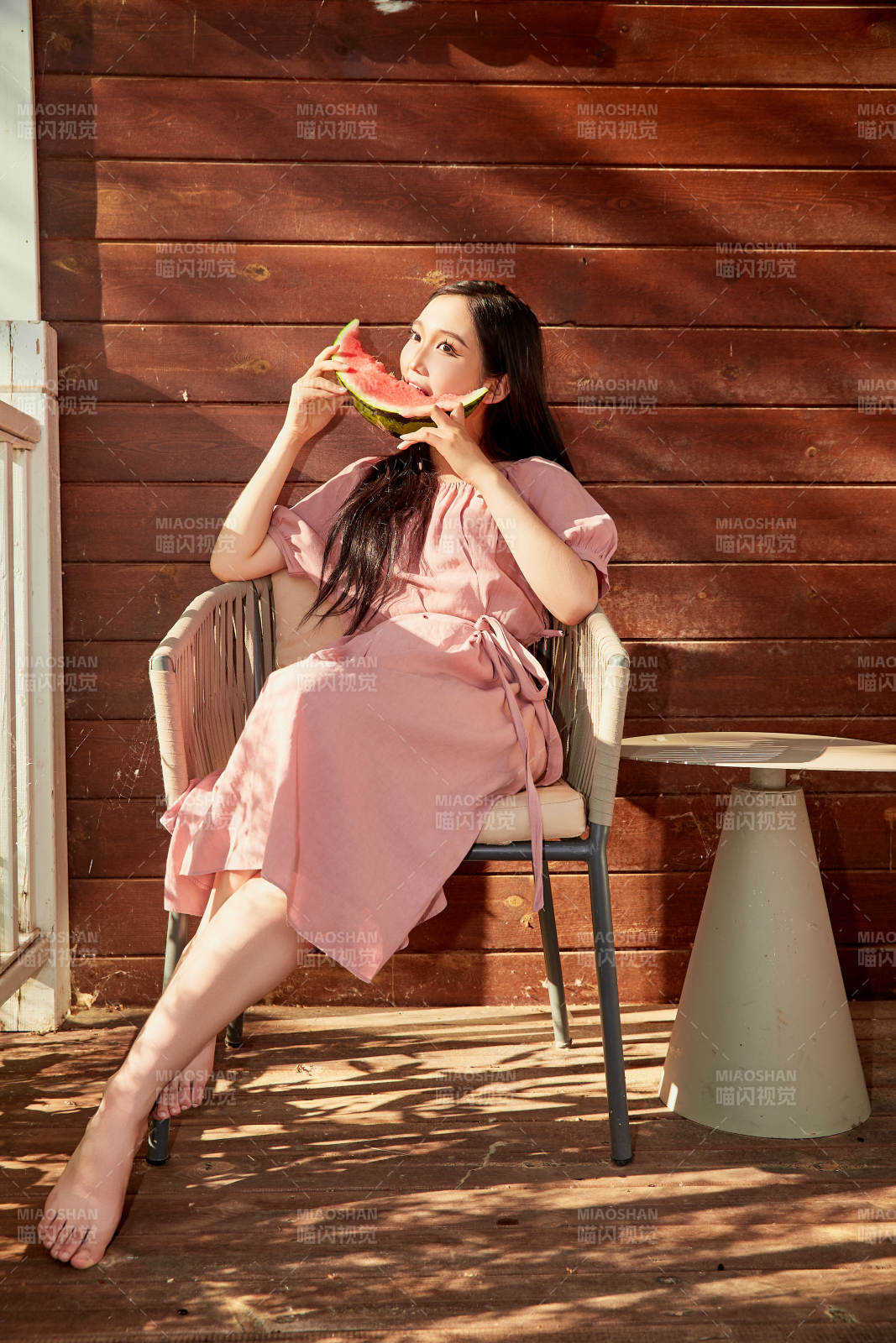 夏天在木質別墅門廊外吃西瓜的美女