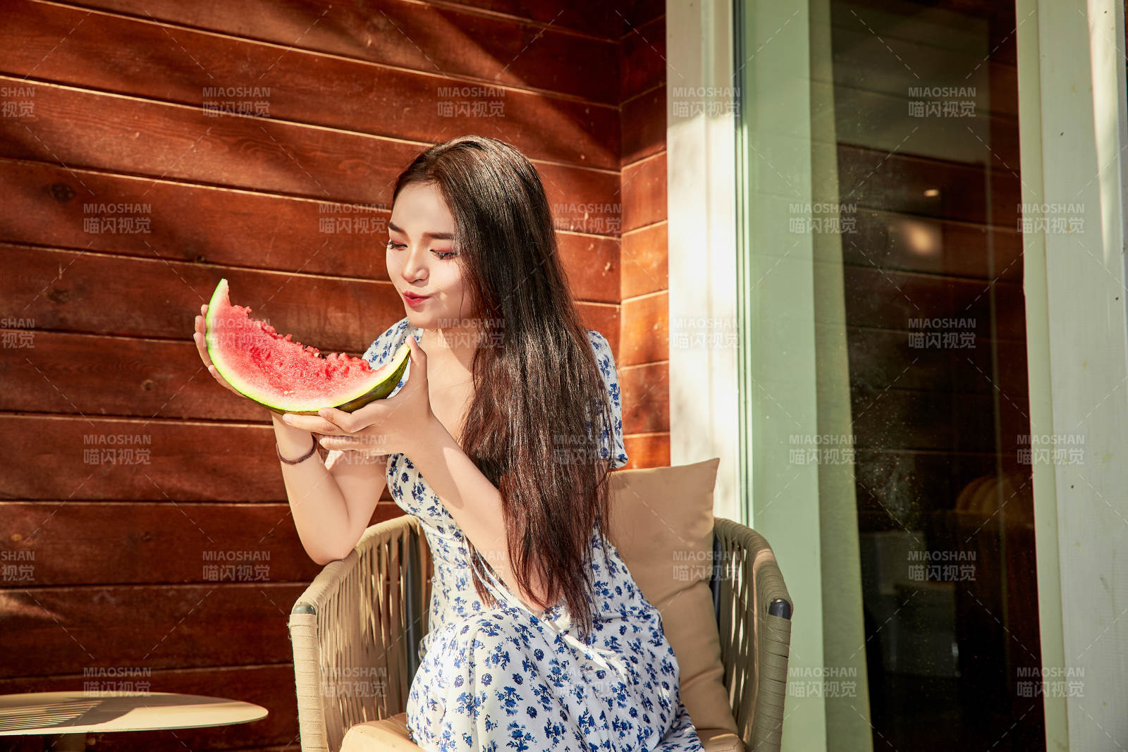 夏天在木質別墅門廊外吃西瓜的美女