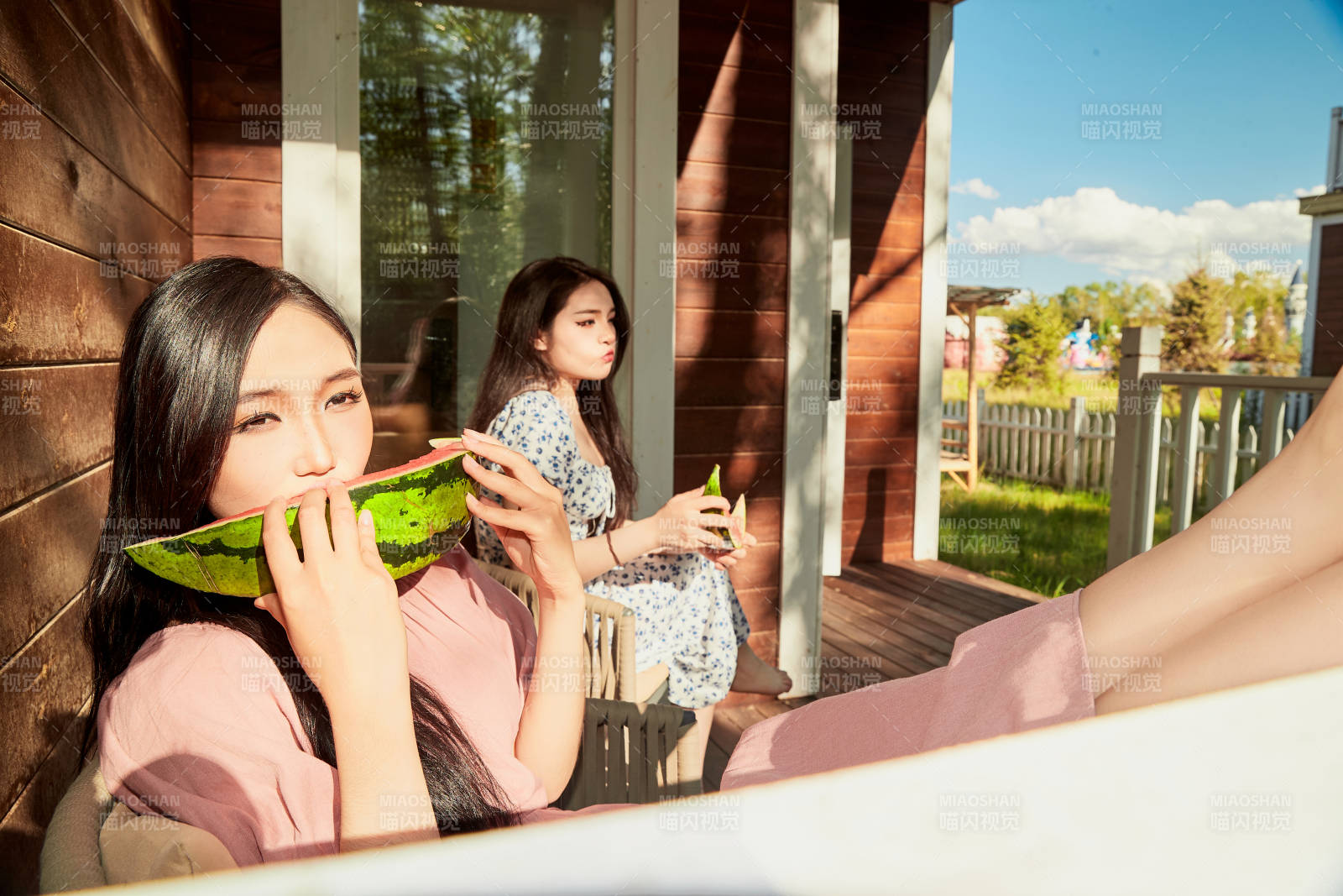 夏天在木質別墅門廊外吃西瓜的美女