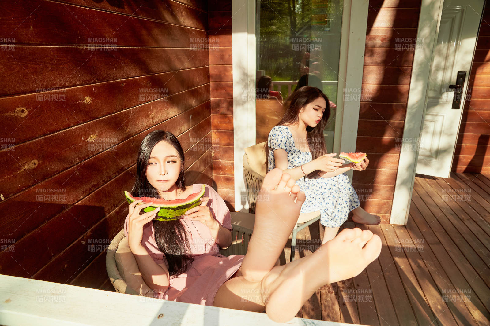 夏天在木質別墅門廊外吃西瓜的美女