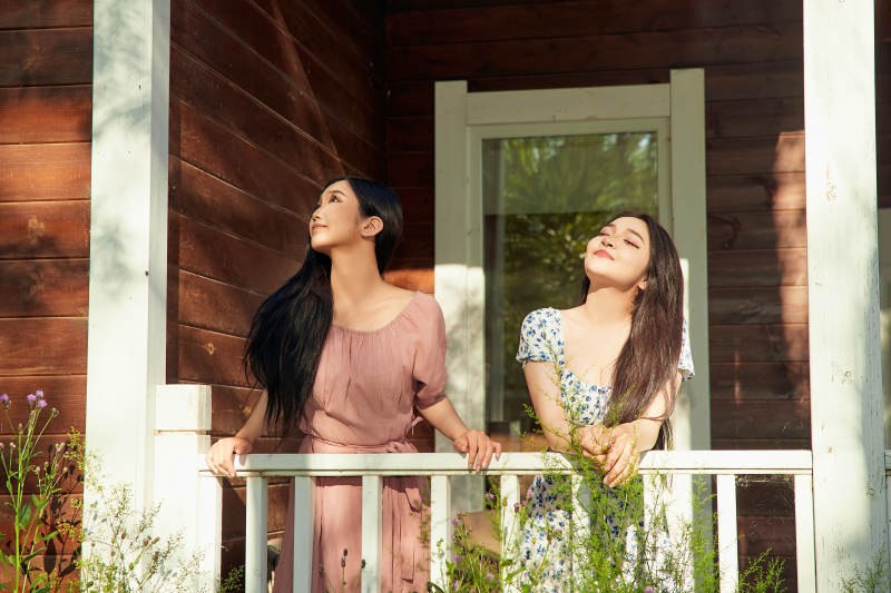 夏天在别墅门庭外拍照欣赏风景的亚洲美女