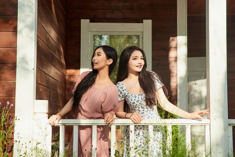 夏天在别墅门庭外拍照欣赏风景的亚洲美女