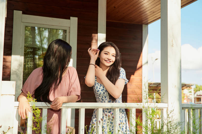 夏天在别墅门庭外拍照欣赏风景的亚洲美女