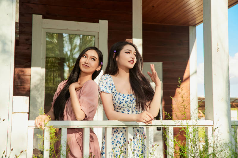 夏天在别墅门庭外拍照欣赏风景的亚洲美女