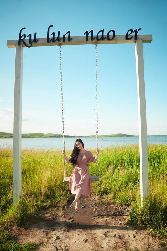 盛夏湖畔荡秋千的亚洲美女