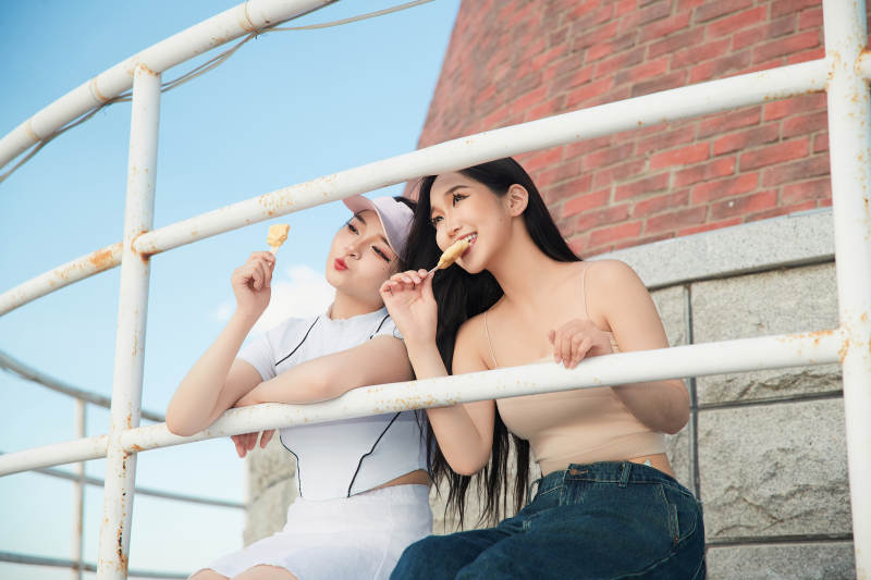 盛夏在景区湖边灯塔上拍照游玩的美女们