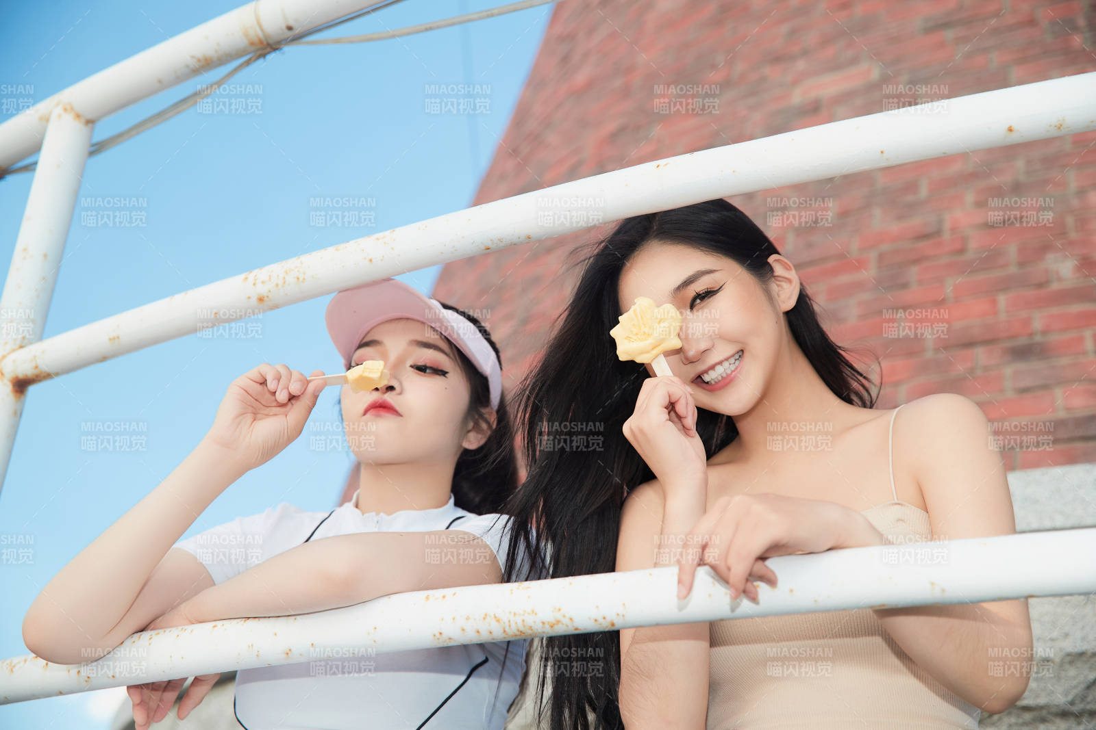 盛夏在景區(qū)湖邊燈塔上拍照游玩的美女們