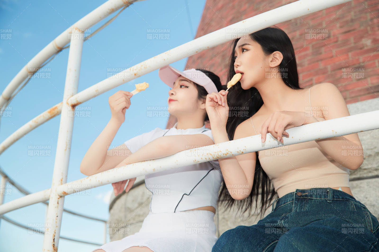 盛夏在景區(qū)湖邊燈塔上拍照游玩的美女們