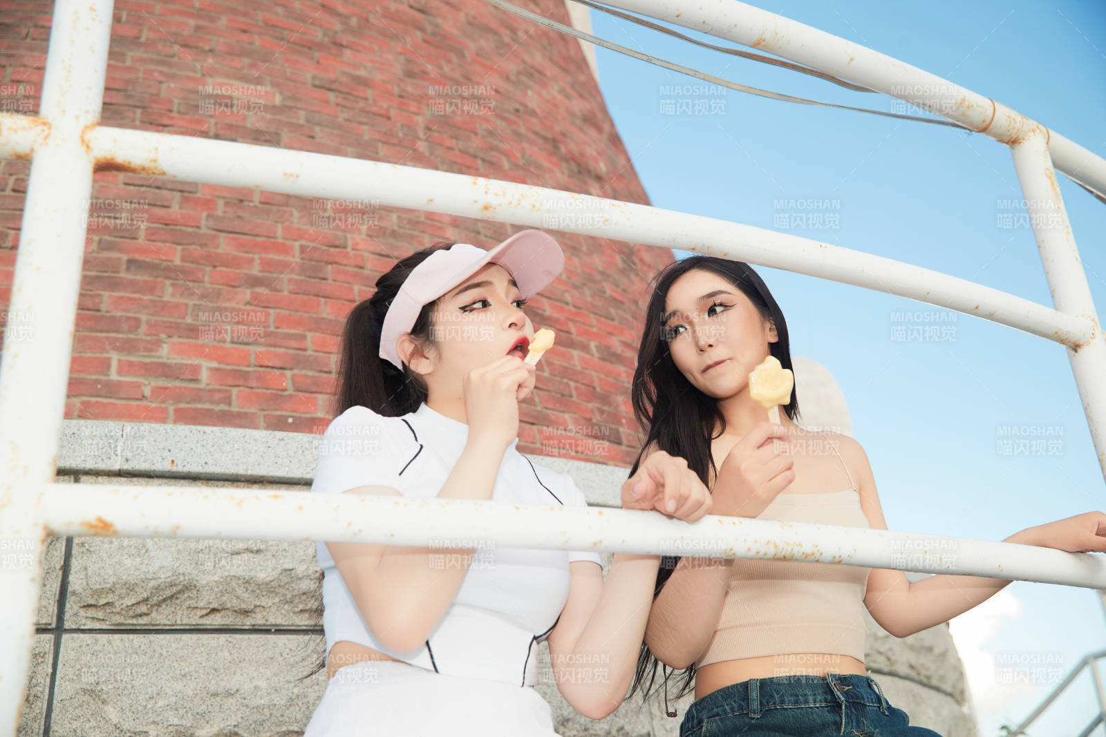 盛夏在景區(qū)湖邊燈塔上拍照游玩的美女們