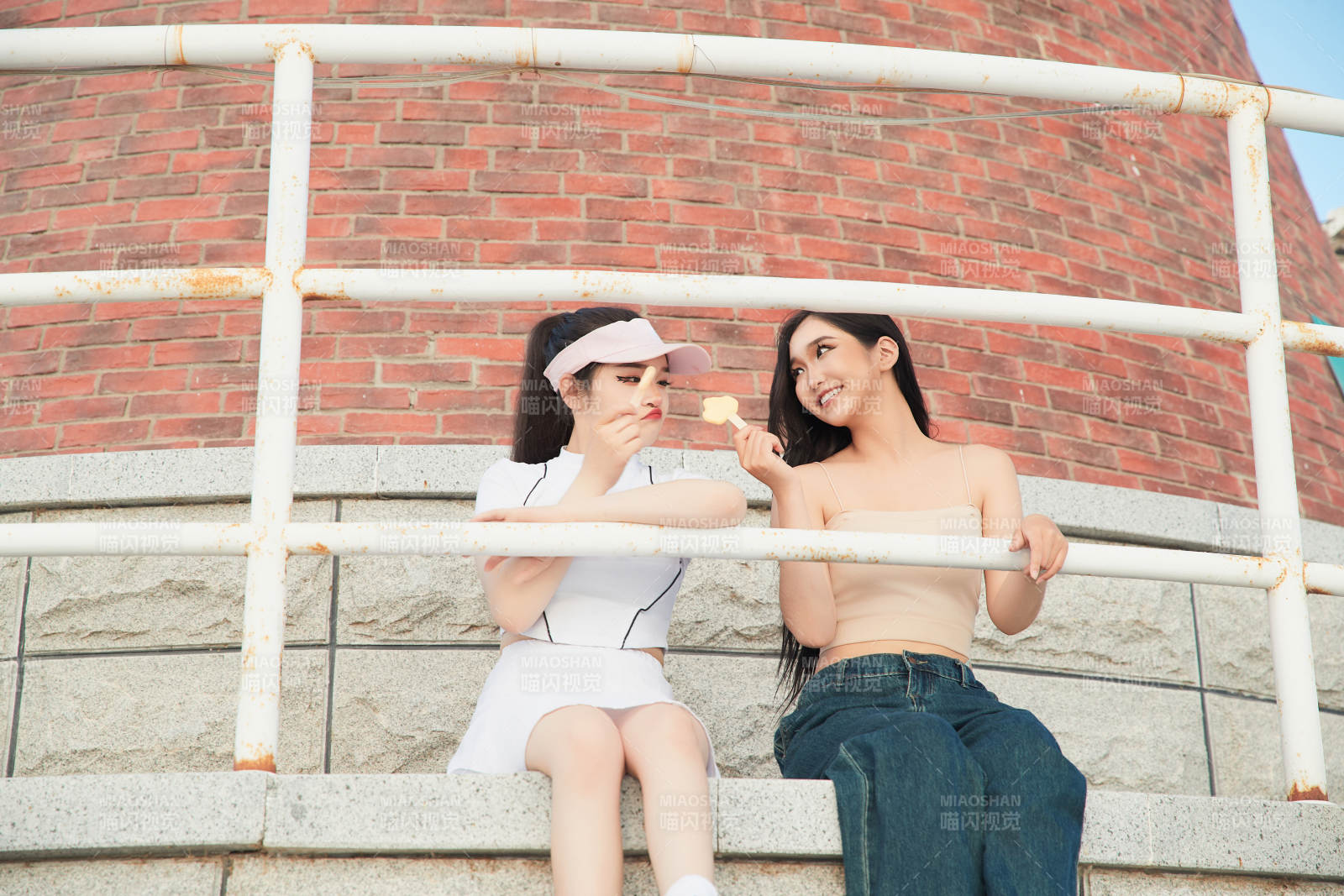 盛夏在景区湖边灯塔上拍照游玩的美女们