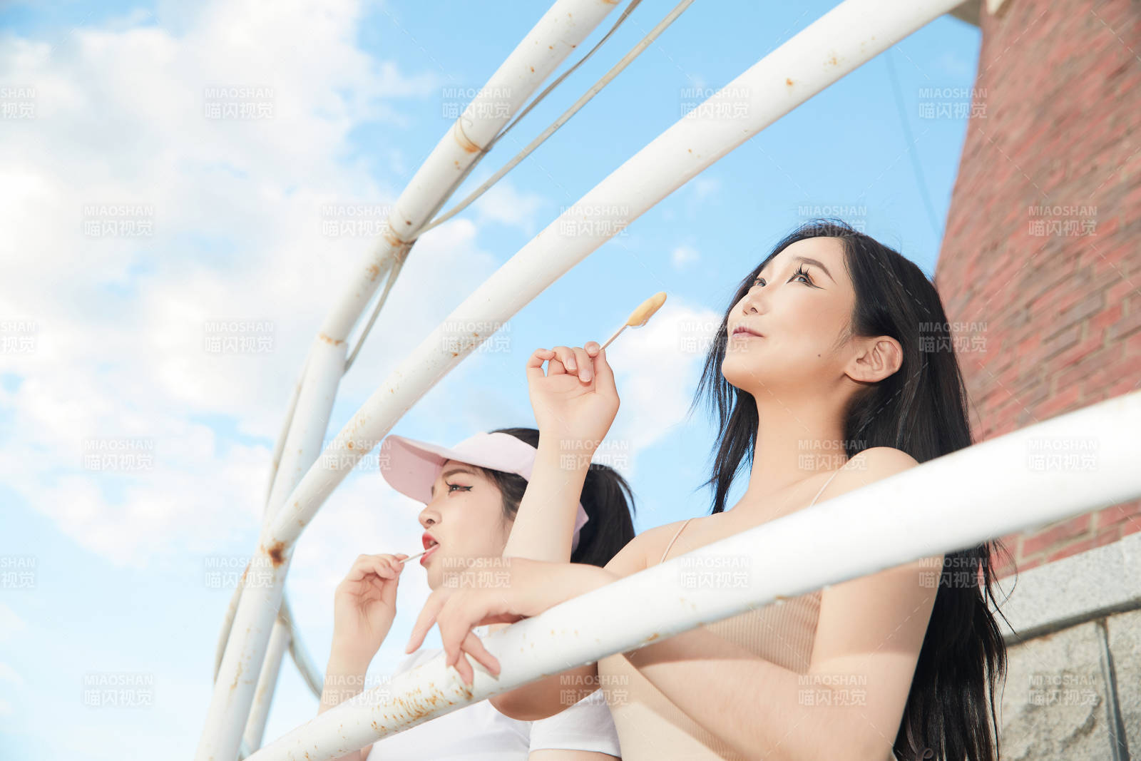 盛夏在景區湖邊燈塔上拍照游玩的美女們