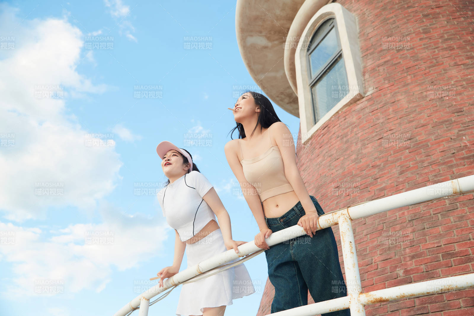 盛夏在景区湖边灯塔上拍照游玩的美女们