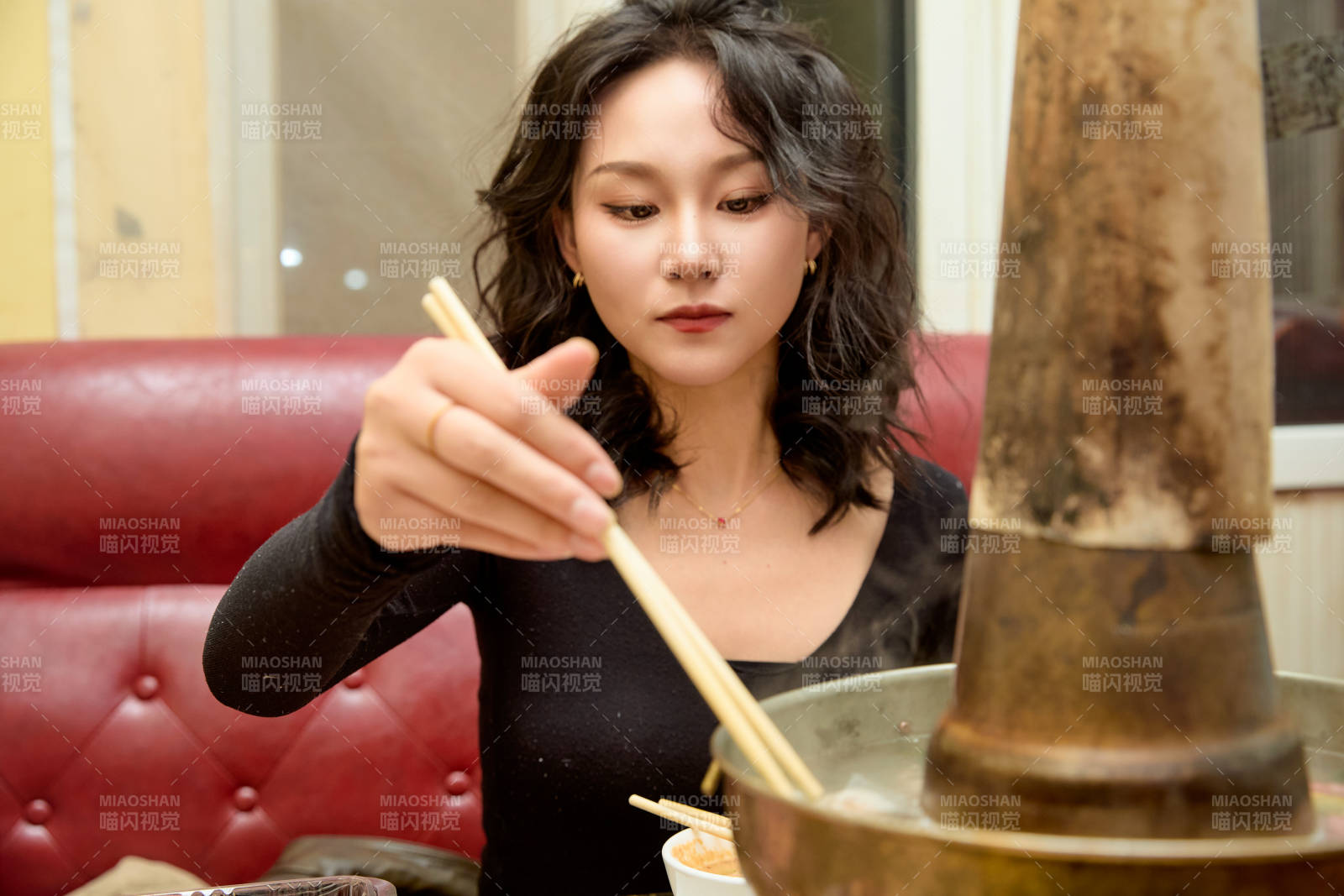 飯店吃傳統(tǒng)銅鍋涮肉的東方美女