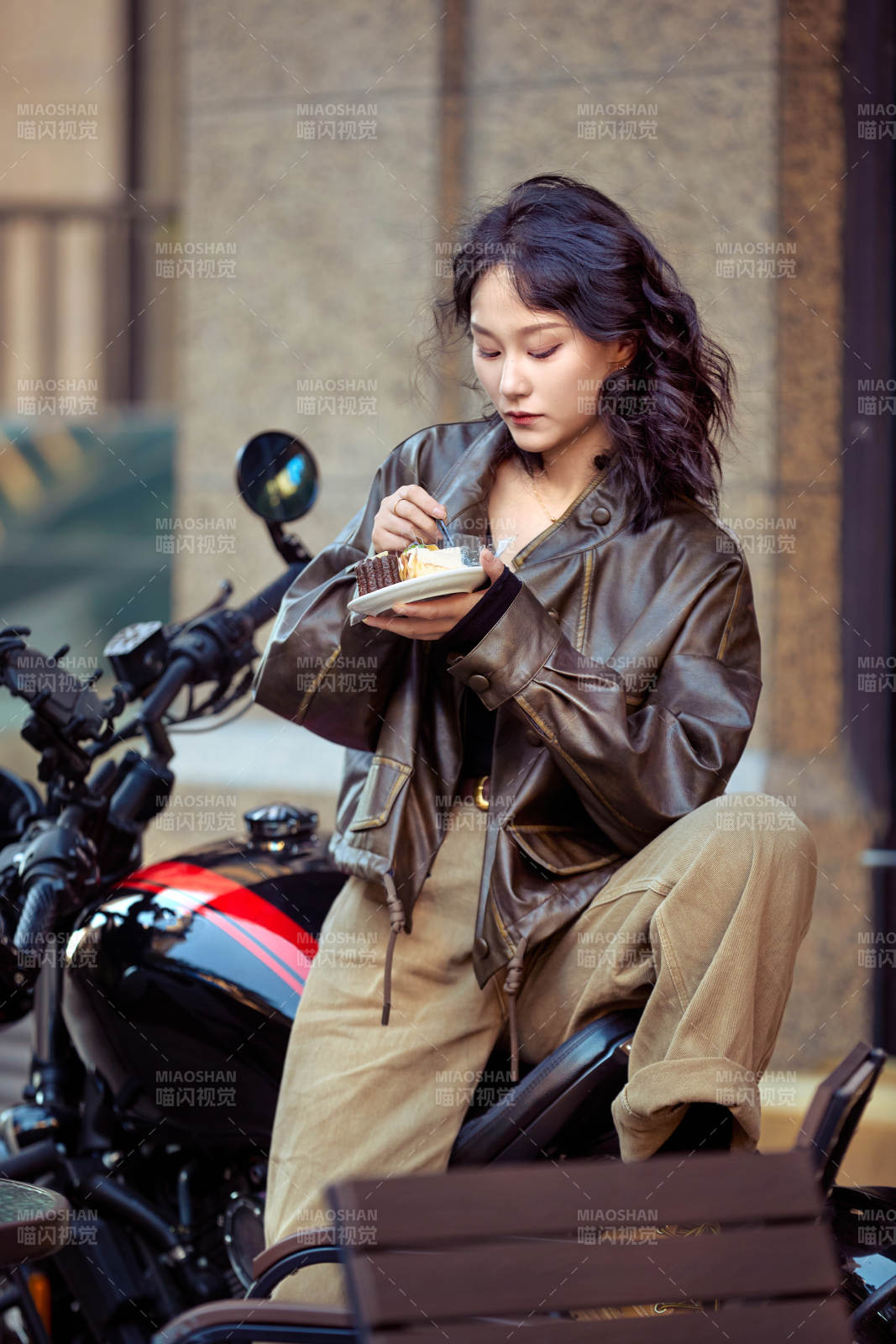 戶外在復古機車上品嘗甜點的亞洲美女