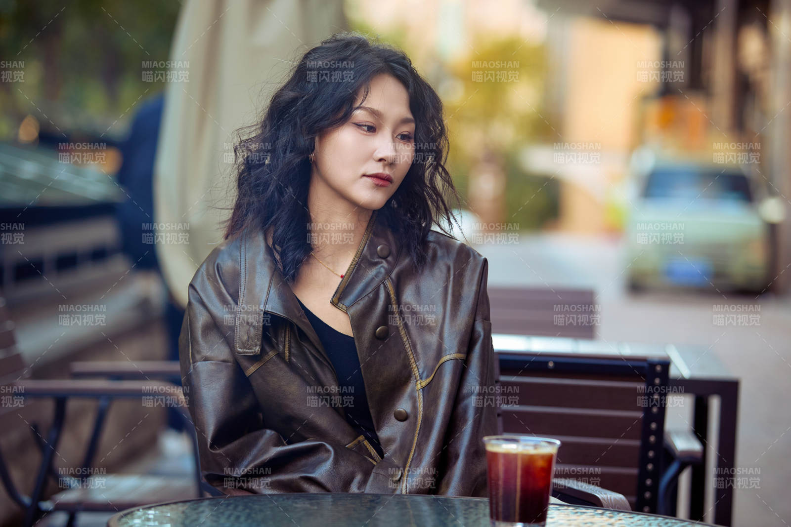 身穿復古皮衣在戶外喝咖啡的東方美女