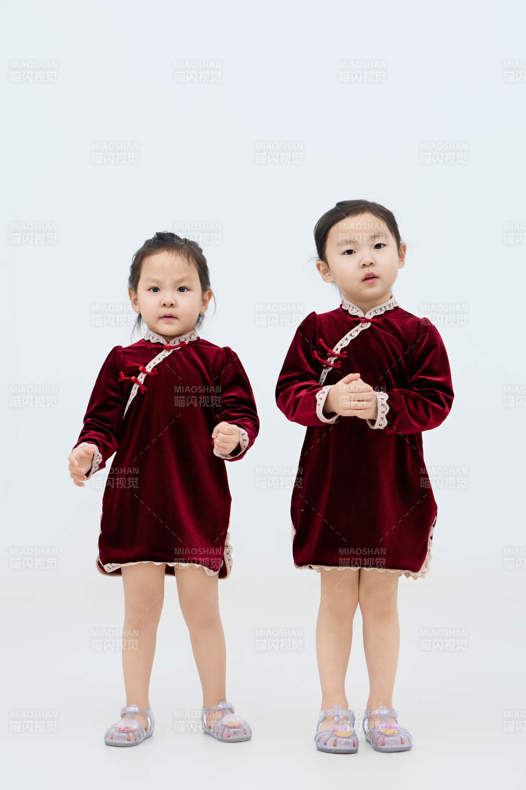 白色背景下頑皮可愛的雙胞胎小女孩-攝影圖