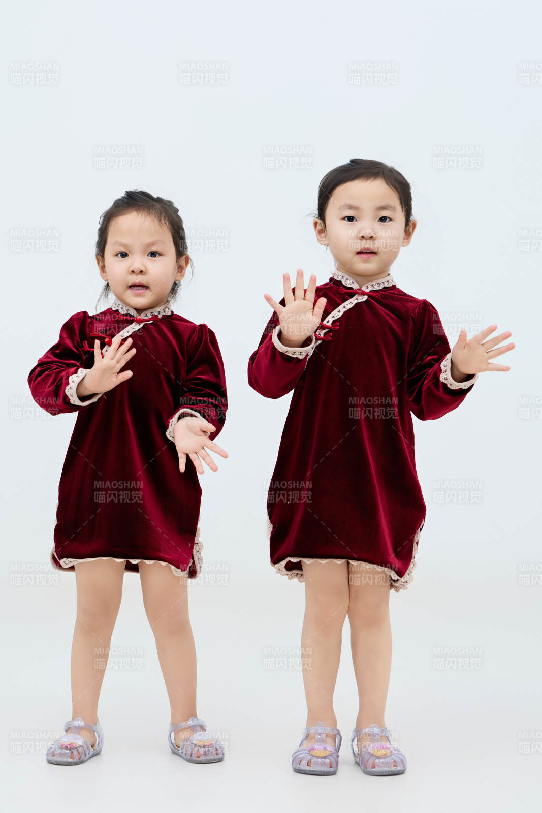 白色背景下頑皮可愛的雙胞胎小女孩