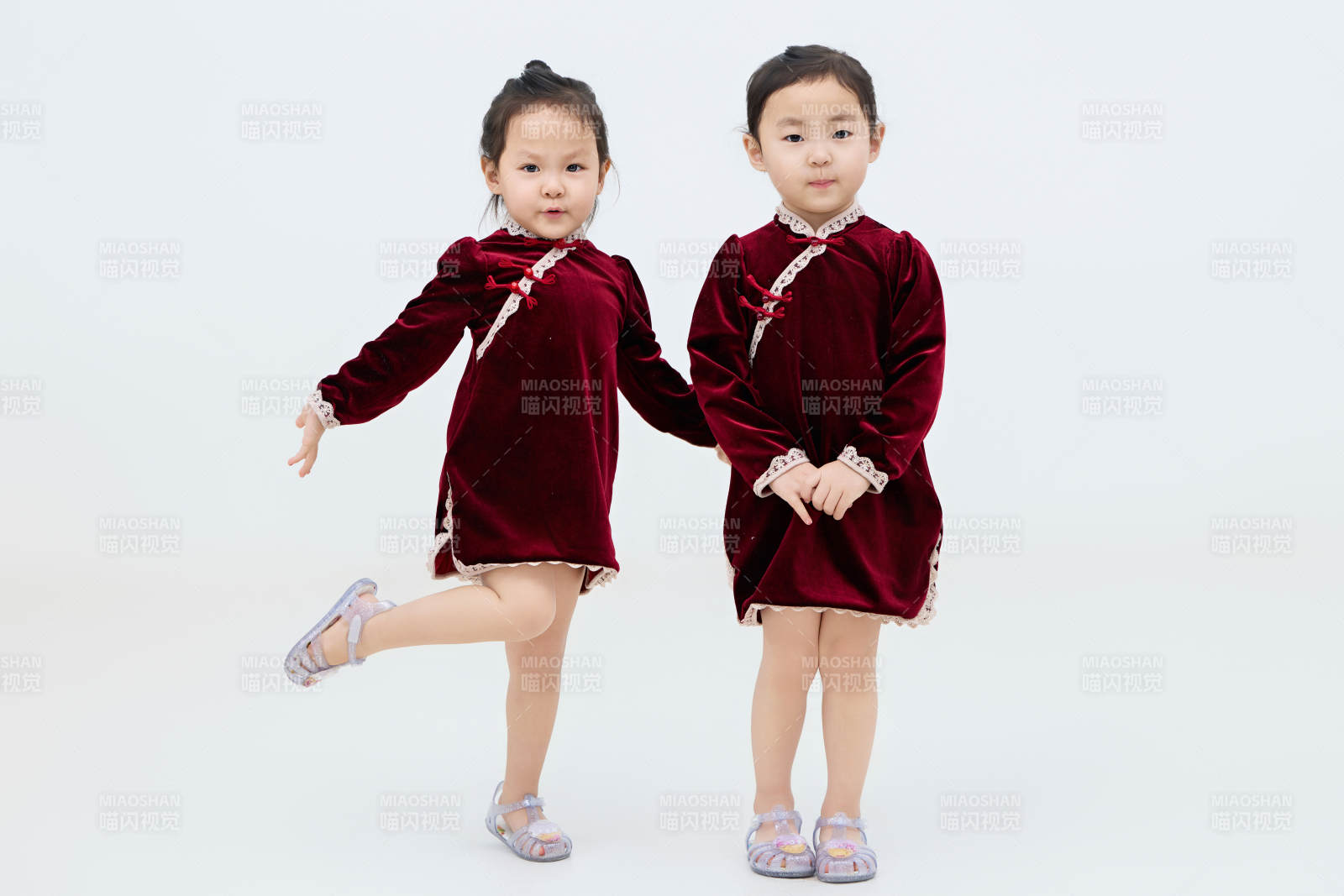 白色背景下頑皮可愛的雙胞胎小女孩