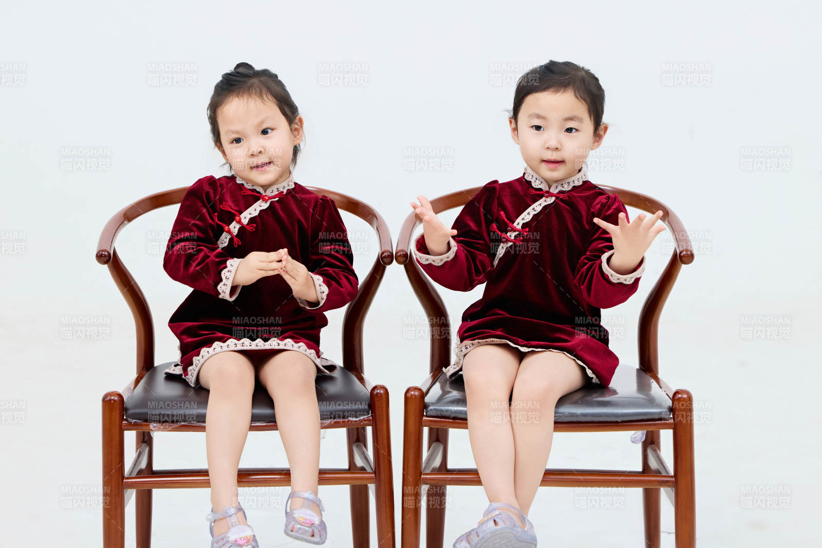 白色背景下顽皮可爱的双胞胎小女孩