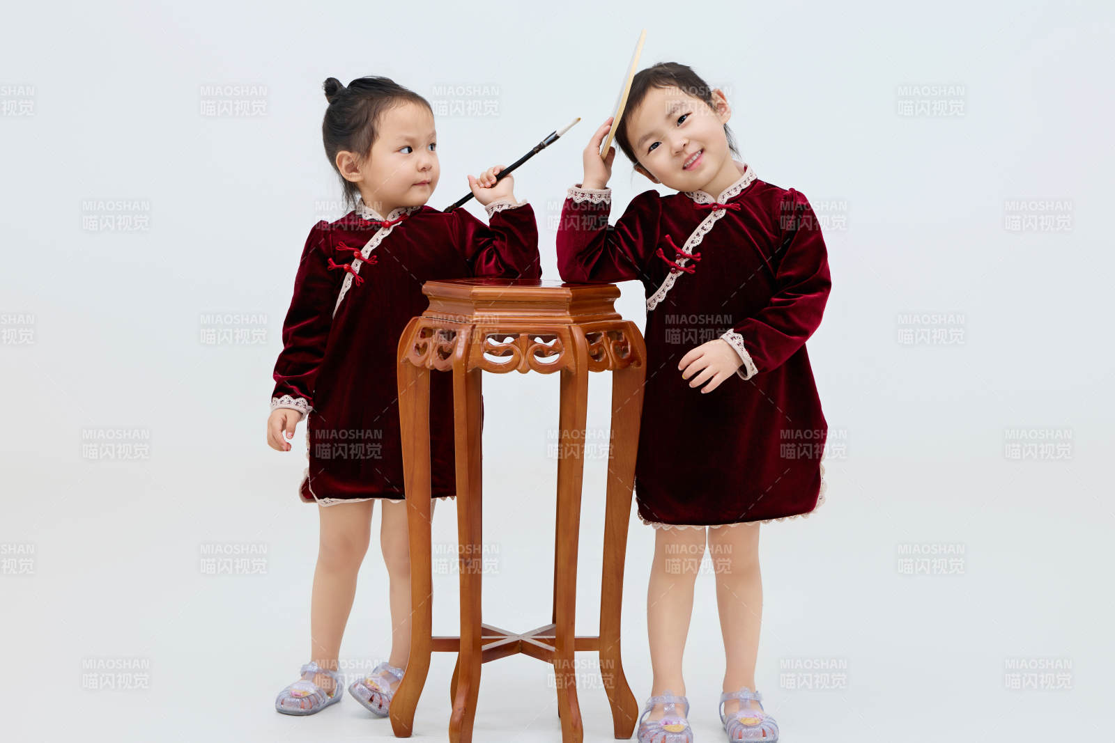 白色背景下顽皮可爱的双胞胎小女孩