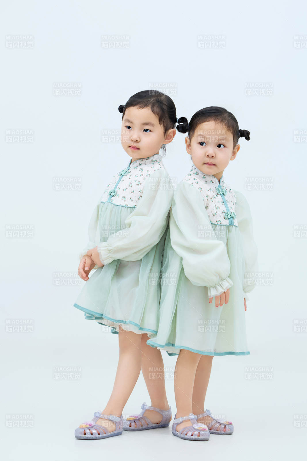 白色背景下頑皮可愛的雙胞胎小女孩
