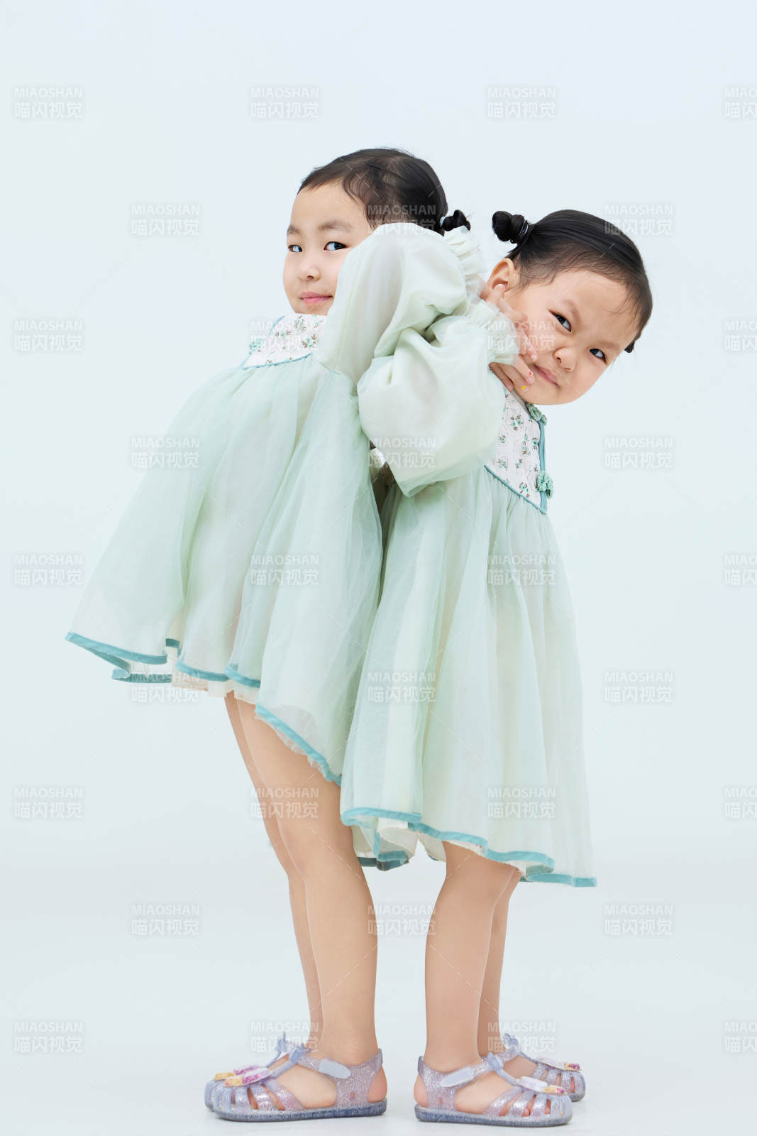 白色背景下頑皮可愛的雙胞胎小女孩