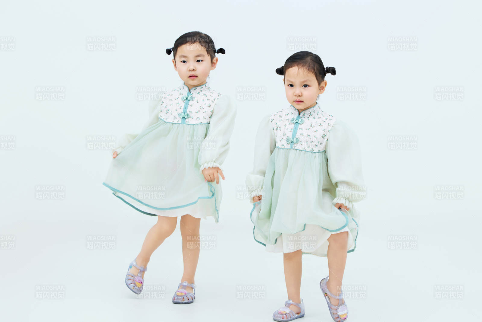 白色背景下頑皮可愛的雙胞胎小女孩