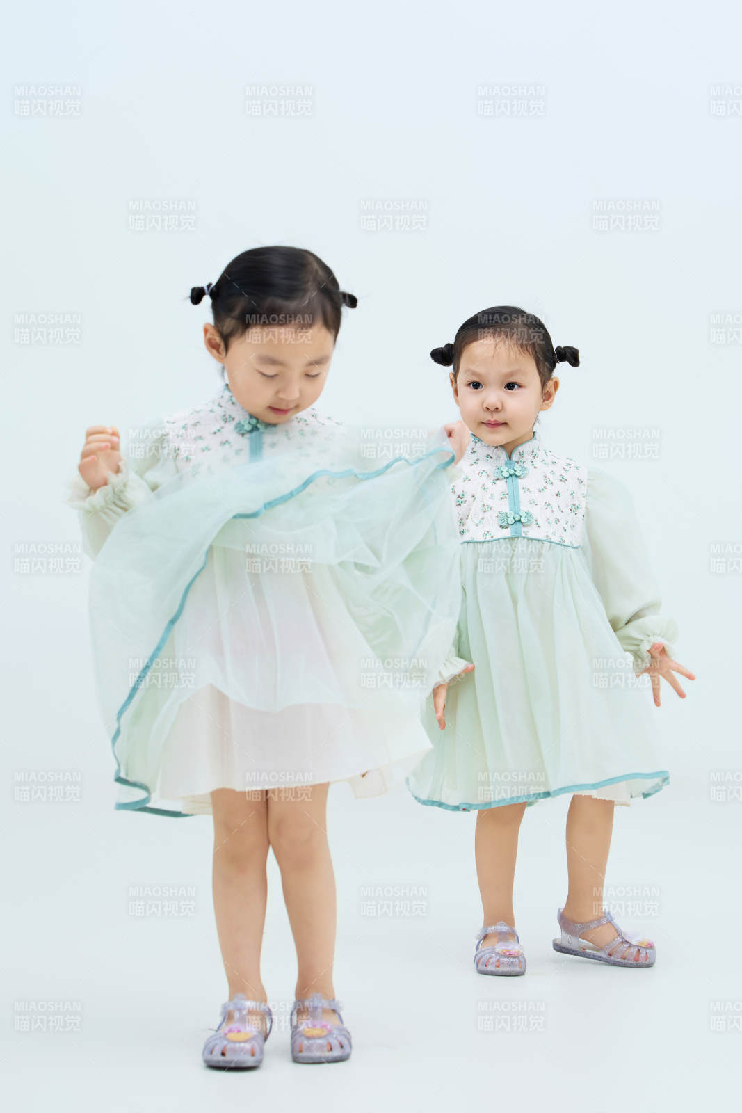 白色背景下頑皮可愛的雙胞胎小女孩