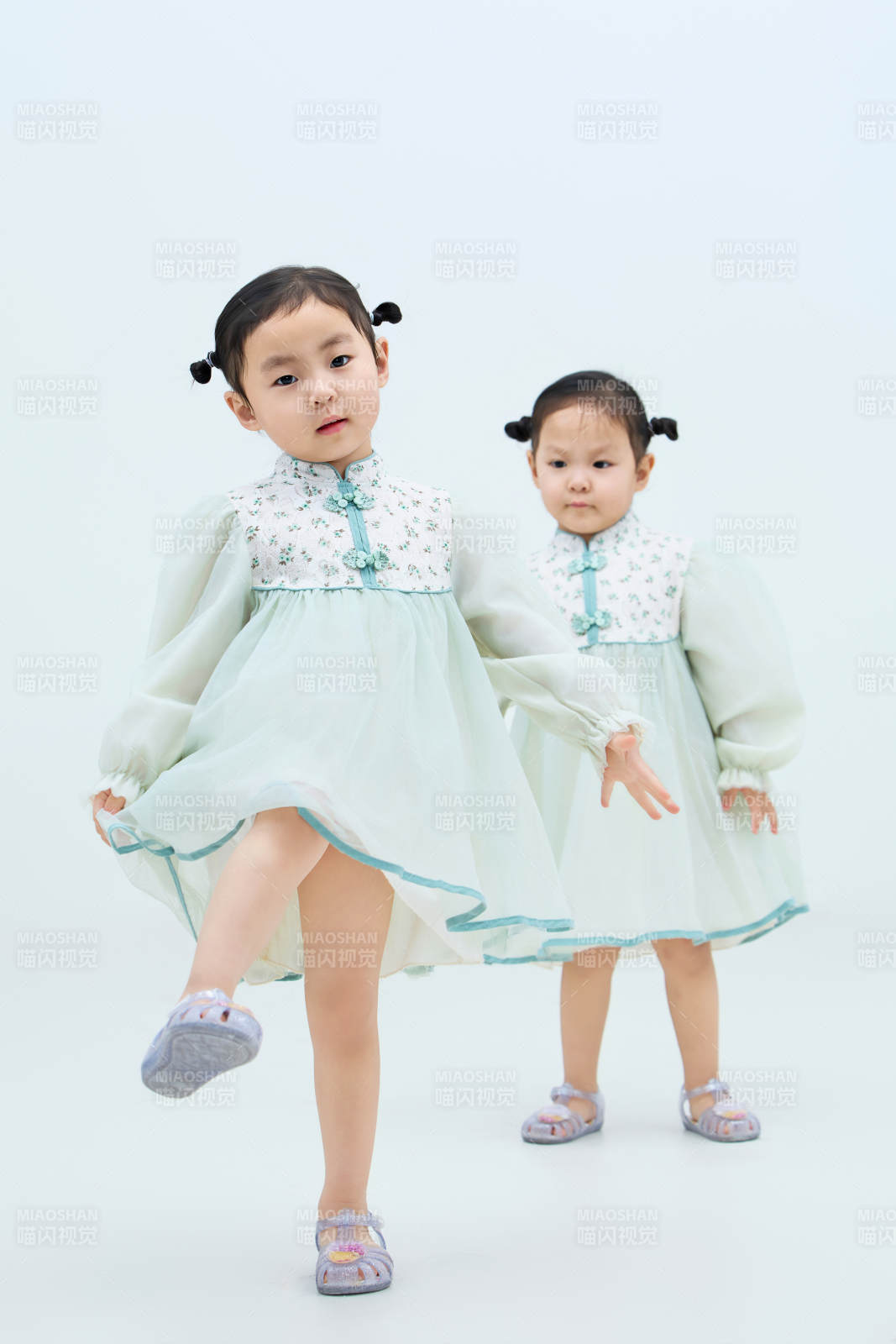 白色背景下頑皮可愛的雙胞胎小女孩