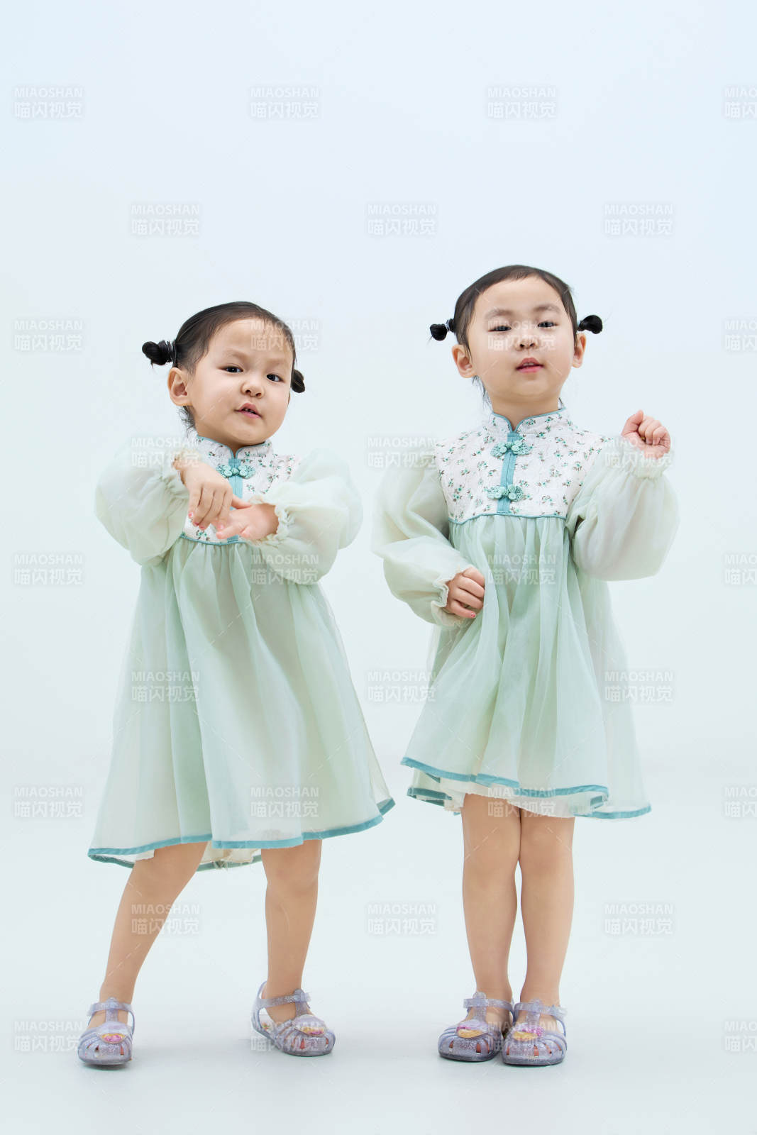 白色背景下頑皮可愛的雙胞胎小女孩