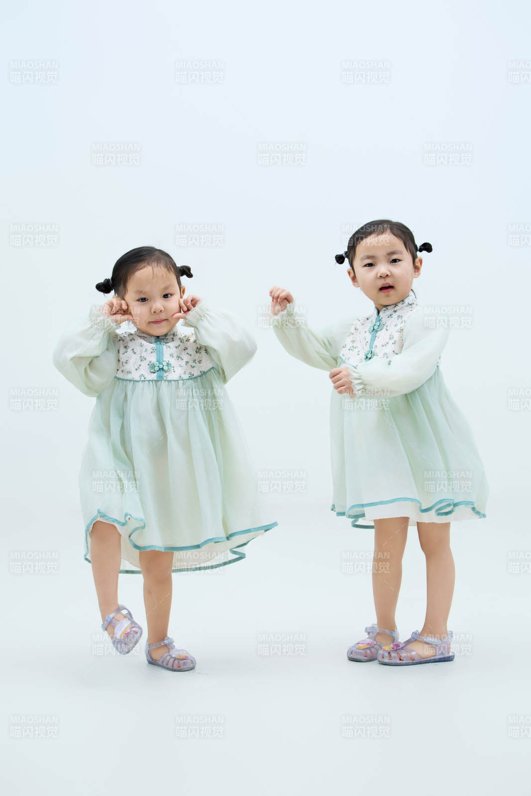 白色背景下頑皮可愛的雙胞胎小女孩