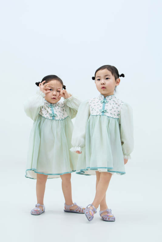 白色背景下顽皮可爱的双胞胎小女孩