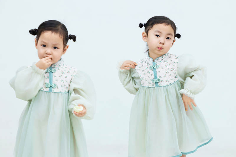 白色背景下顽皮可爱的双胞胎小女孩