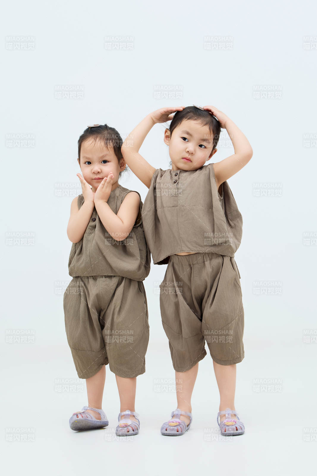 白色背景下頑皮可愛的雙胞胎小女孩