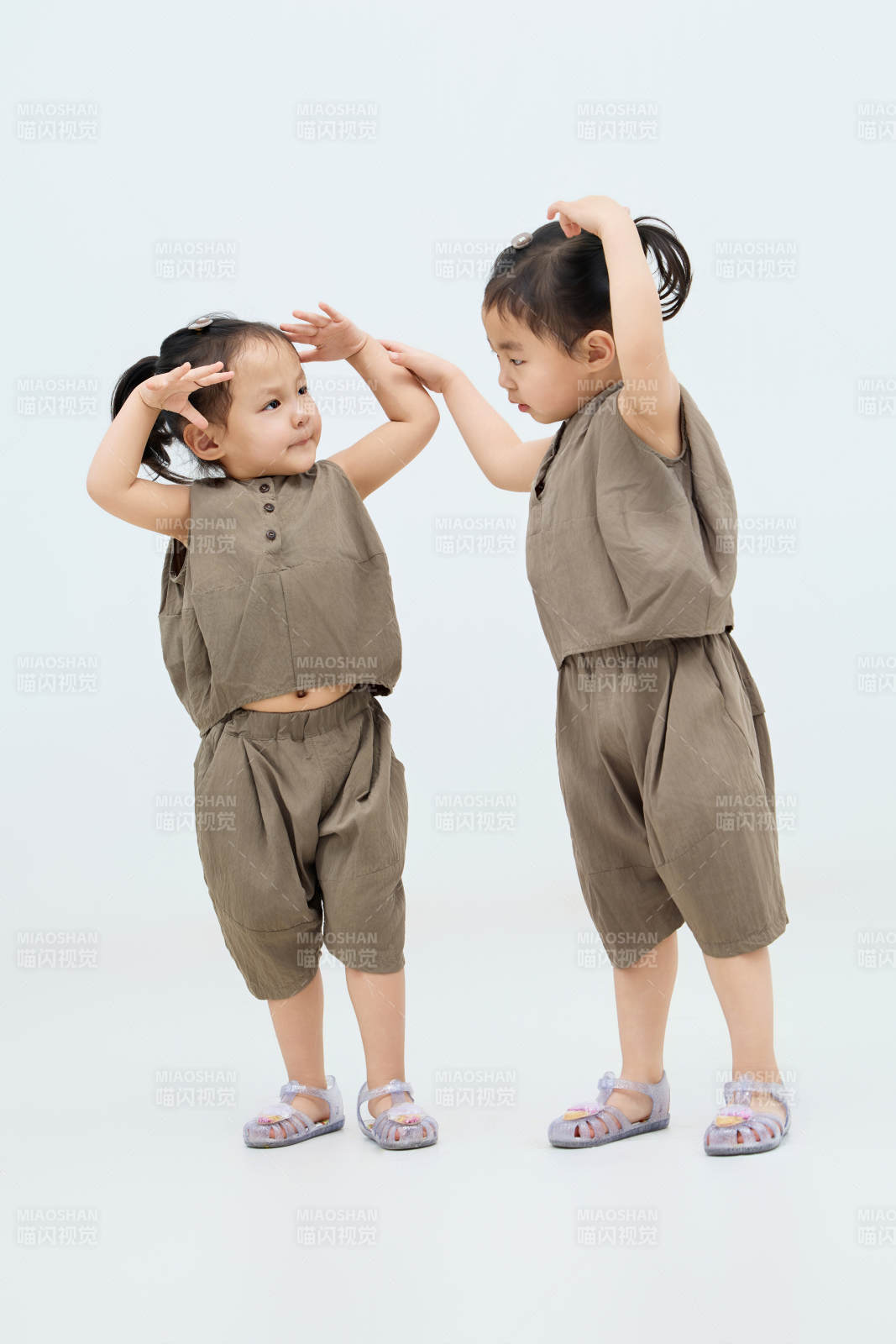 白色背景下頑皮可愛的雙胞胎小女孩