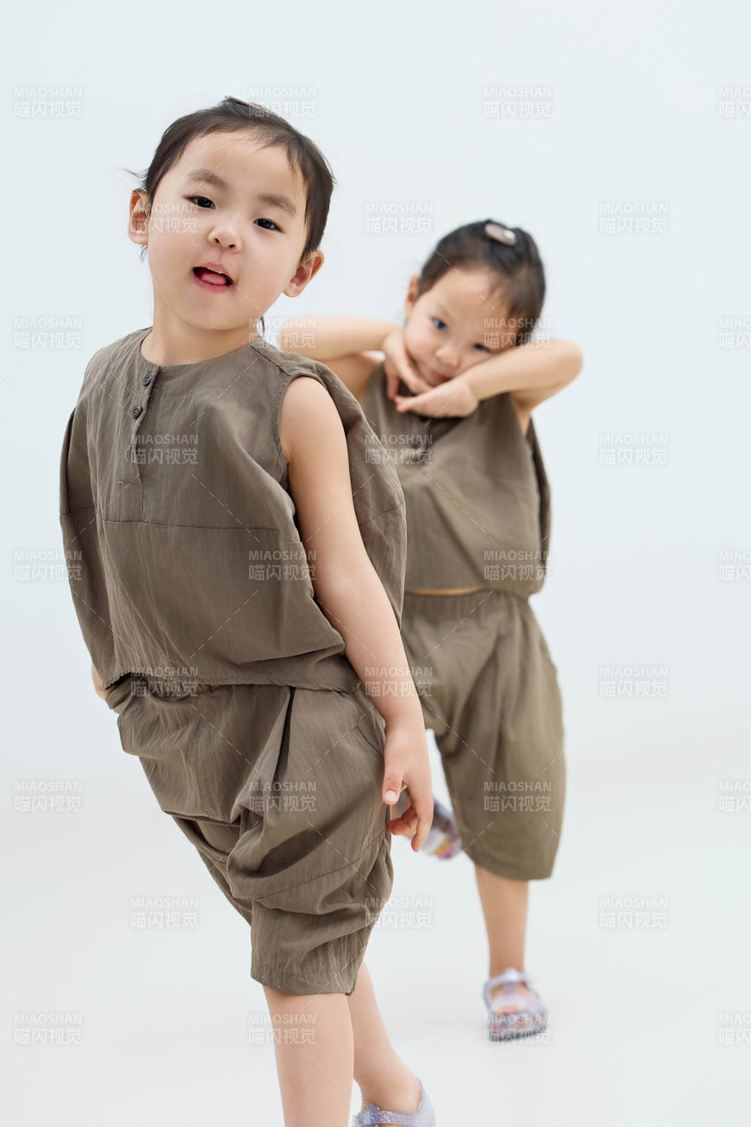 白色背景下頑皮可愛的雙胞胎小女孩