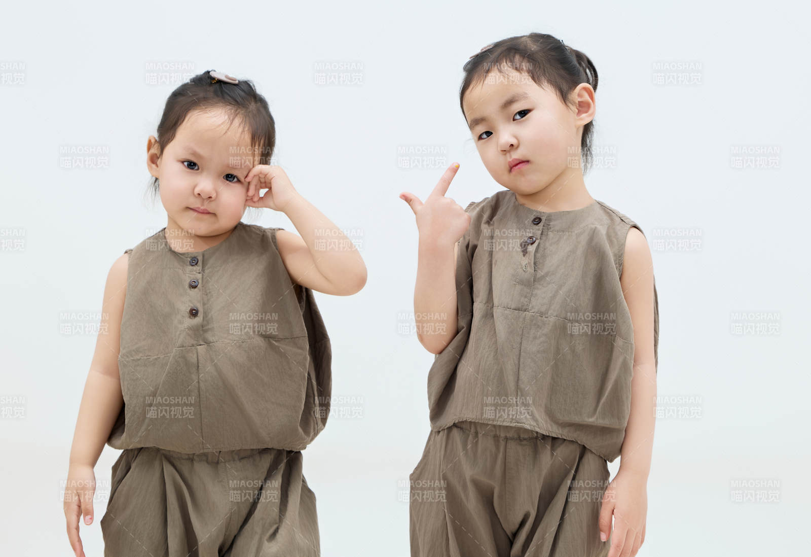 白色背景下頑皮可愛的雙胞胎小女孩