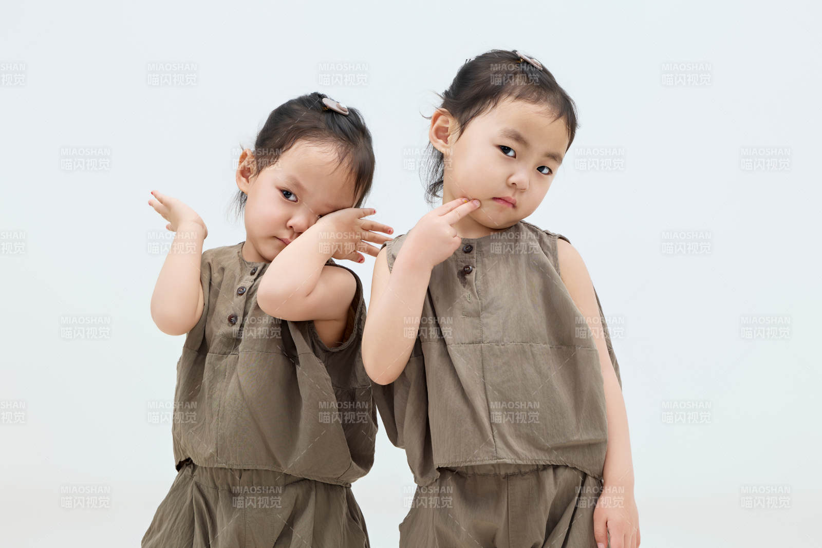 白色背景下顽皮可爱的双胞胎小女孩