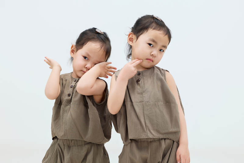 白色背景下顽皮可爱的双胞胎小女孩