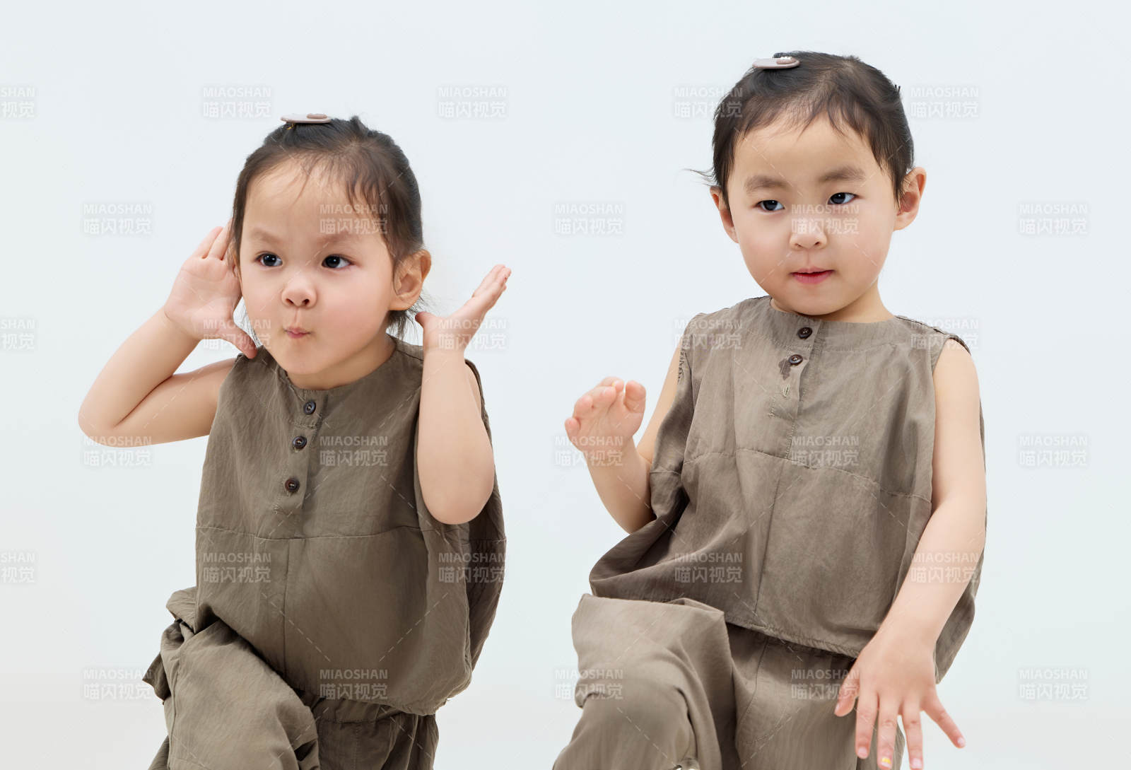 白色背景下顽皮可爱的双胞胎小女孩