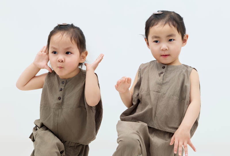 白色背景下顽皮可爱的双胞胎小女孩