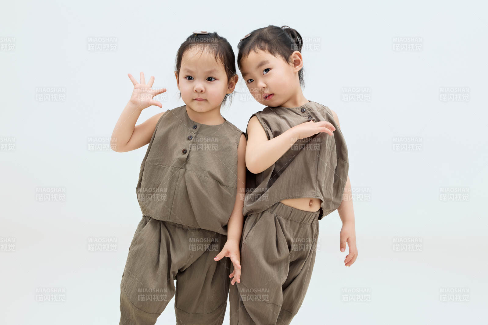 白色背景下頑皮可愛的雙胞胎小女孩