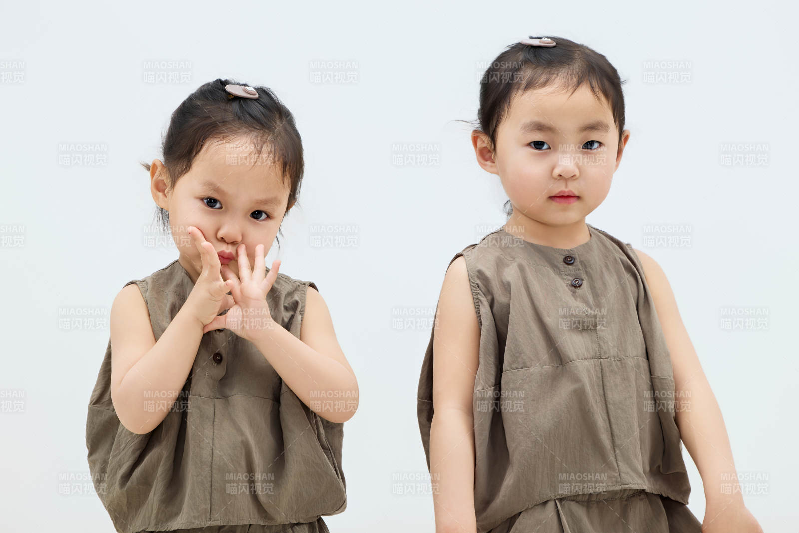 白色背景下頑皮可愛的雙胞胎小女孩